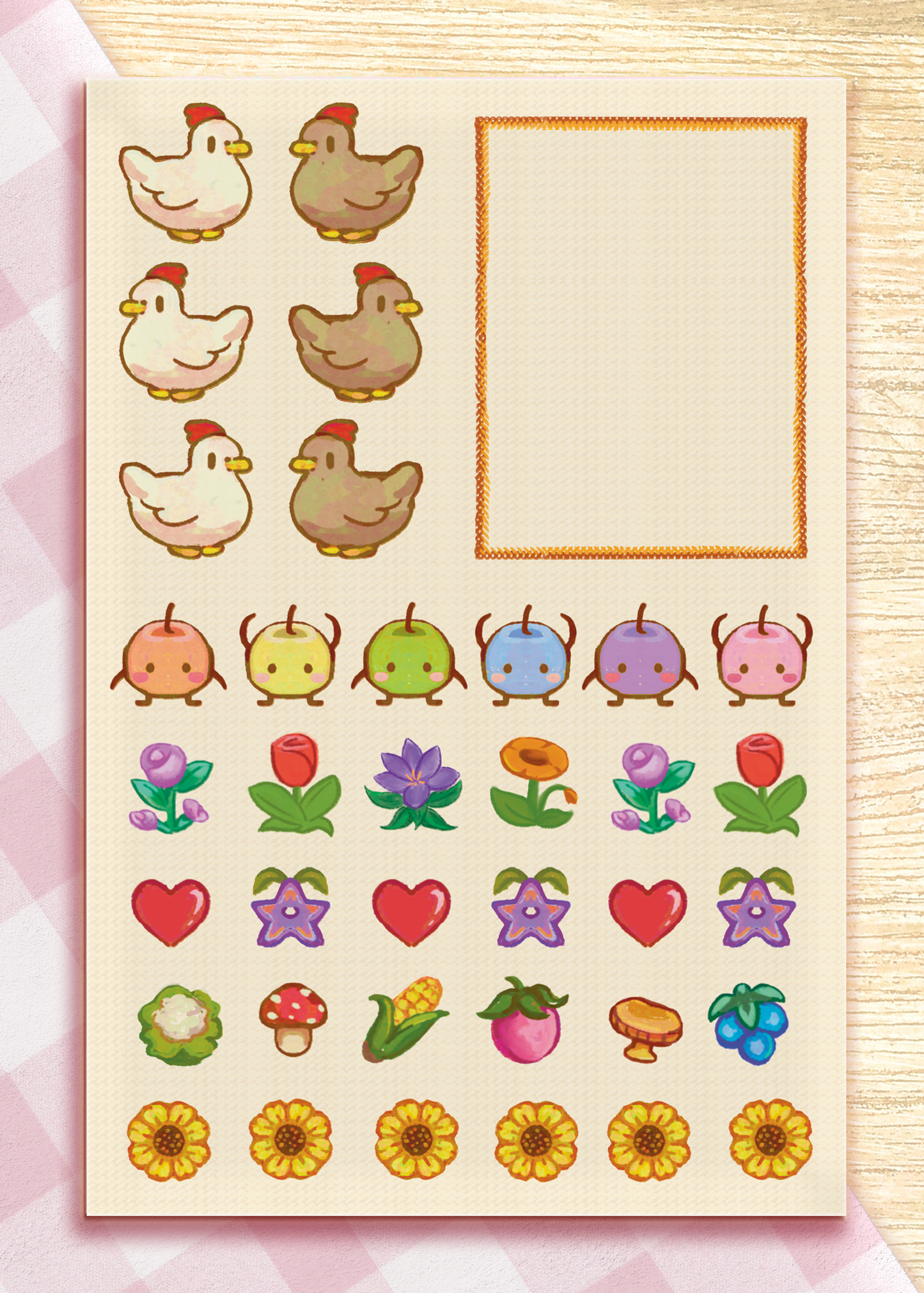 A sheet of cute planner stickers featuring cartoon chickens, colorful flowers, fruits, mushrooms, and sunflowers, alongside a blank grid box, displayed on a light wood background.