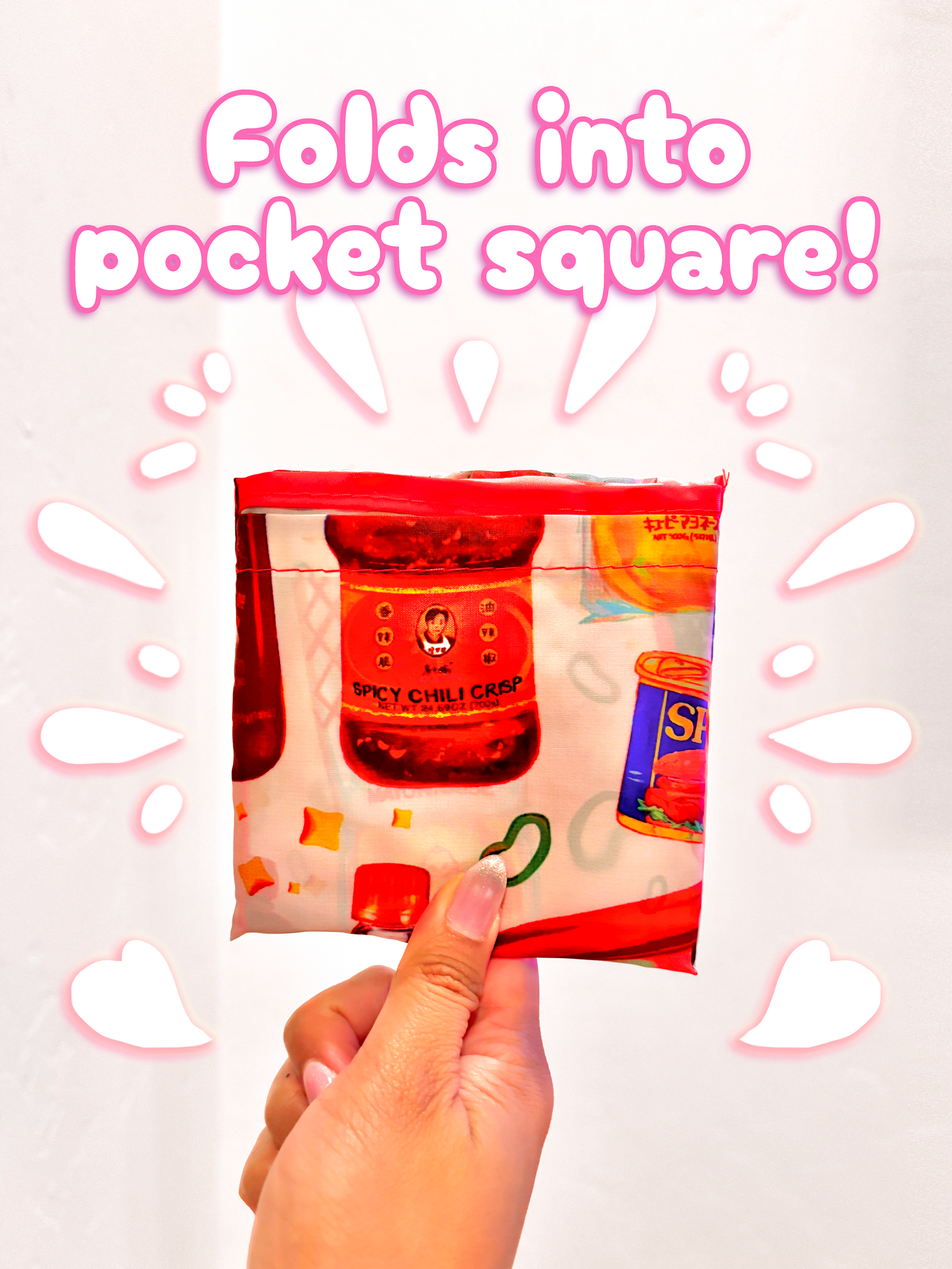 Hand holding a small package with text 'Folds into pocket square!' on a light pink background