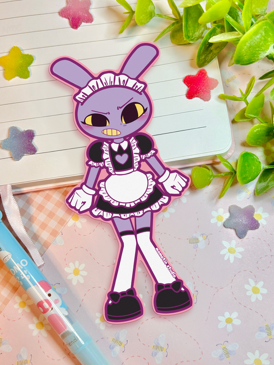 A die-cut sticker of a purple cartoon bunny in a black and white maid outfit, displayed on a lined notebook with decorative green leaves, star stickers, and a pastel pen.
